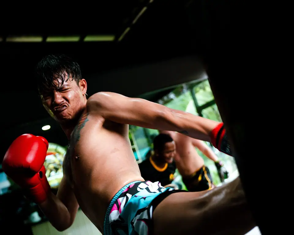A fighter kicking a heavy bag