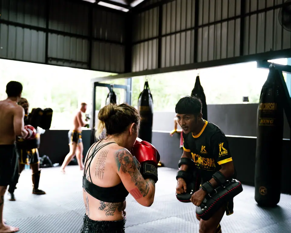 A visitor working on pads with a coach