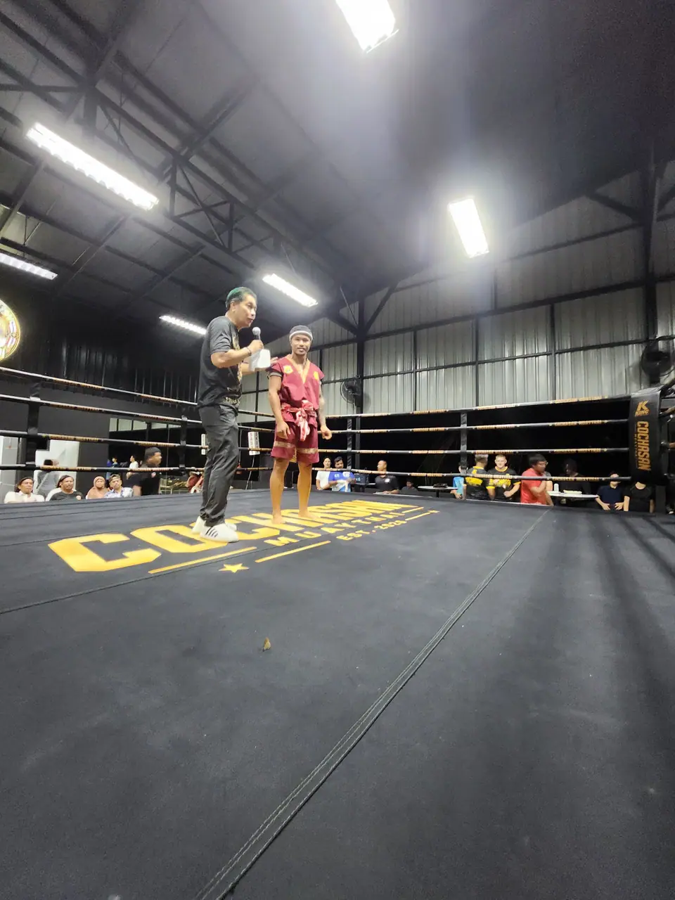A coach teaching a child in the ring
