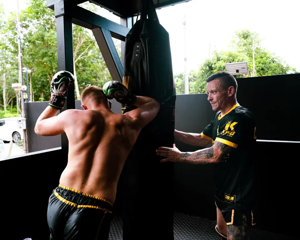 A coach holding the bag for a student